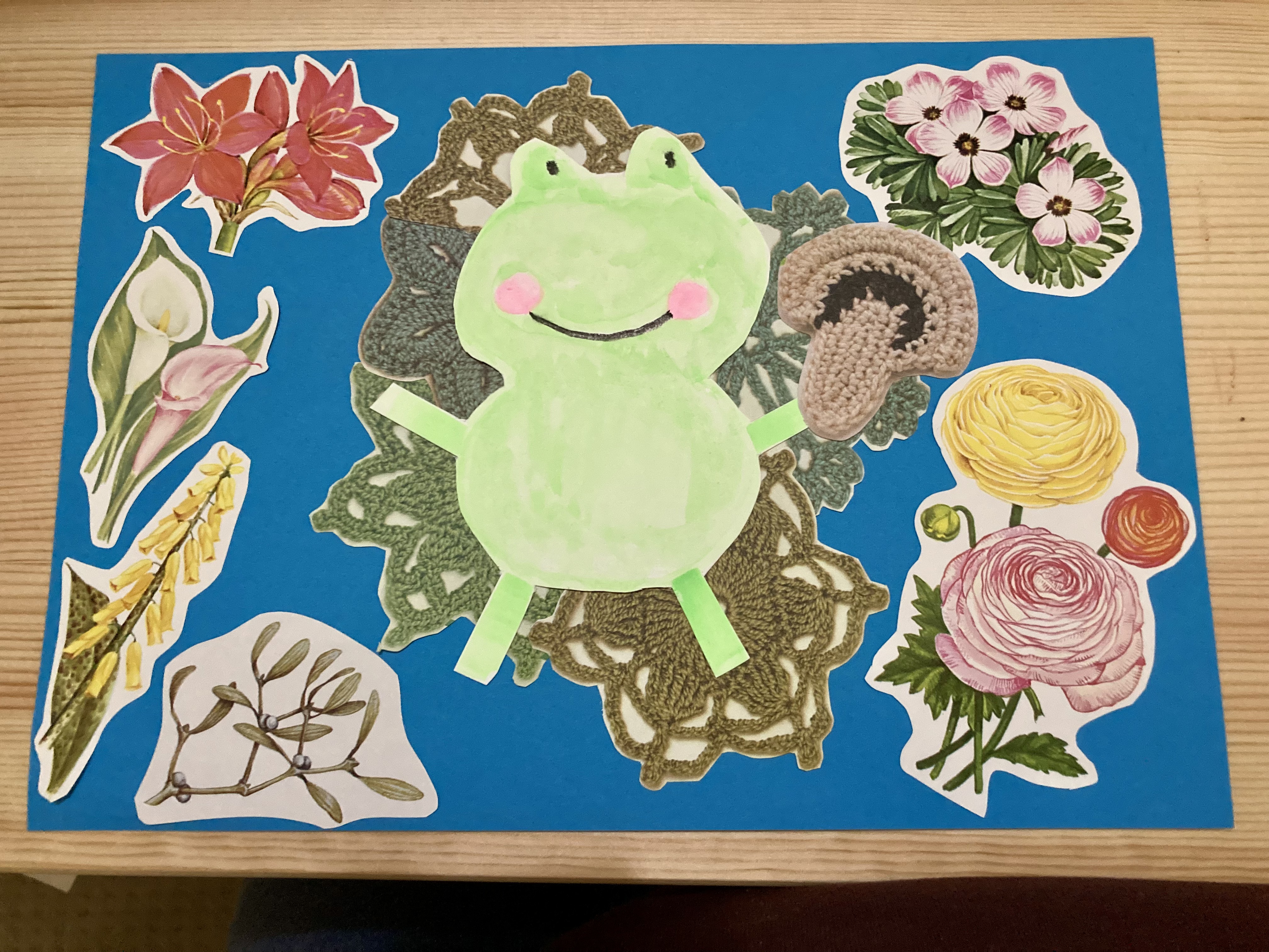 A collage. The cartoon frog from earlier in the gallery sits of a lilypad made of green crocheted doilies, surrounded by flowers.