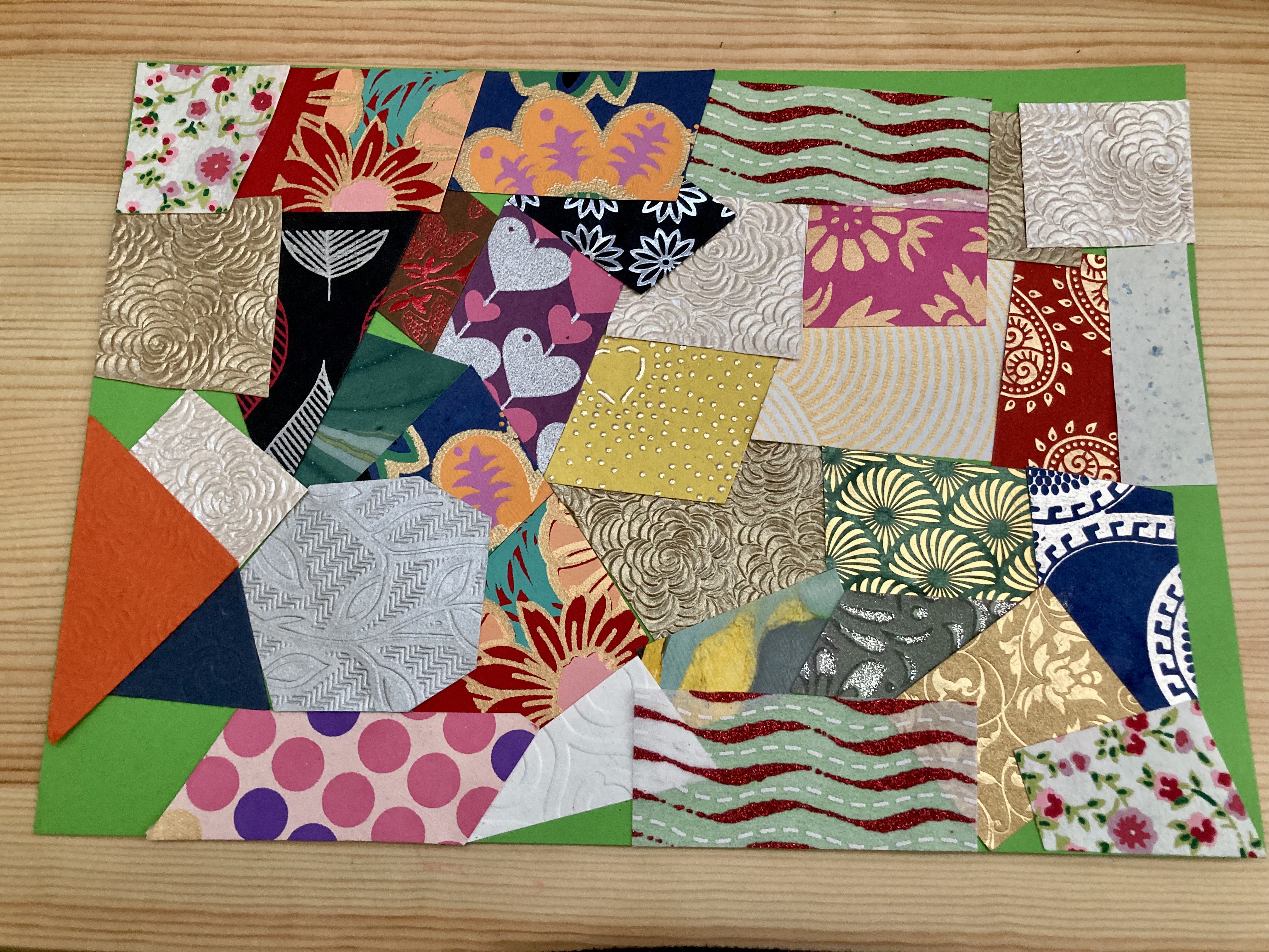 A collage of many small pieces of colourful paper and fabric.